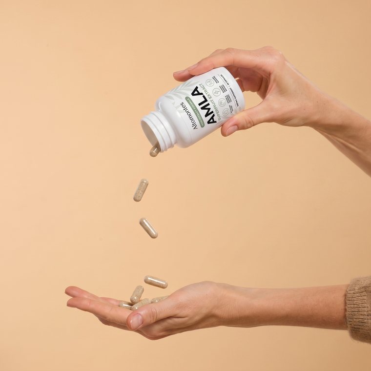 Amla capsules poured into a hand